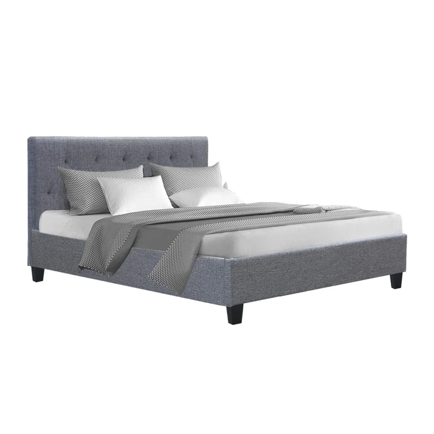 Grey upholstered bed frame with tufted headboard, white and patterned bedding