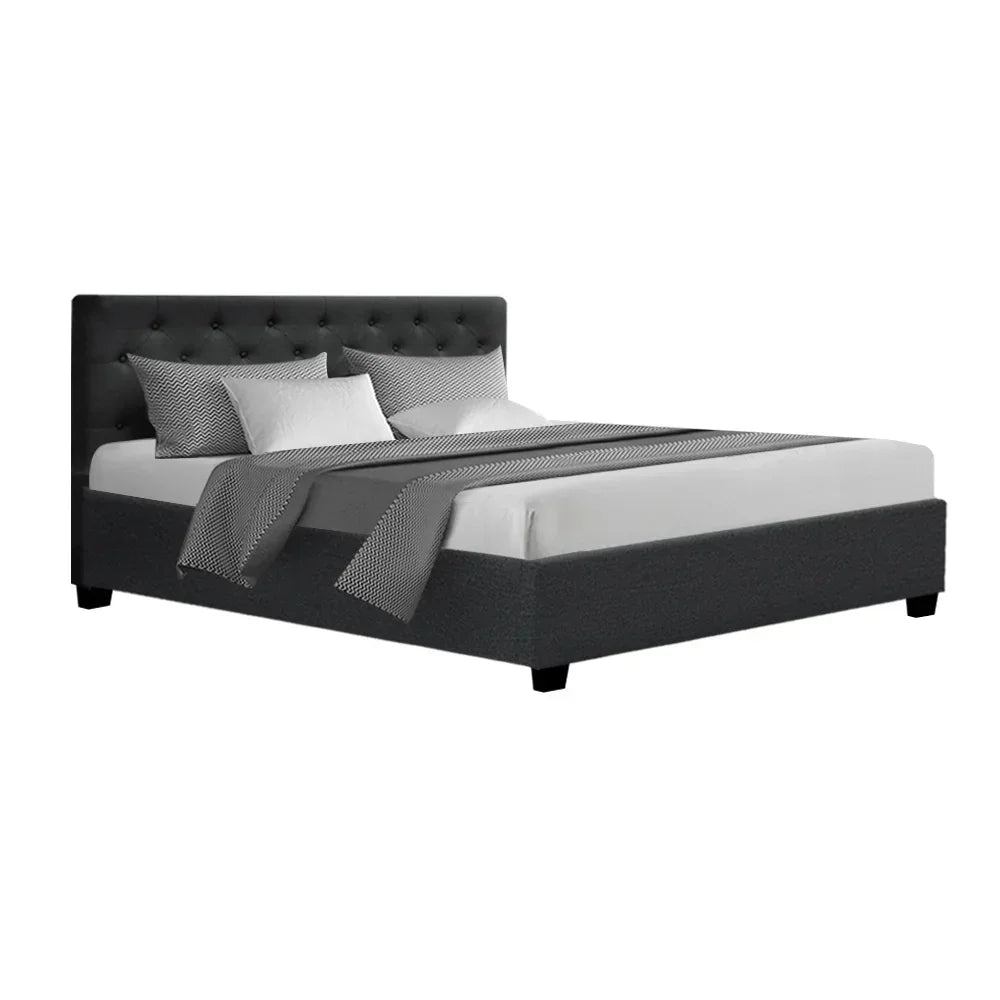 Modern charcoal upholstered bed frame with tufted headboard and bedding, isolated on white