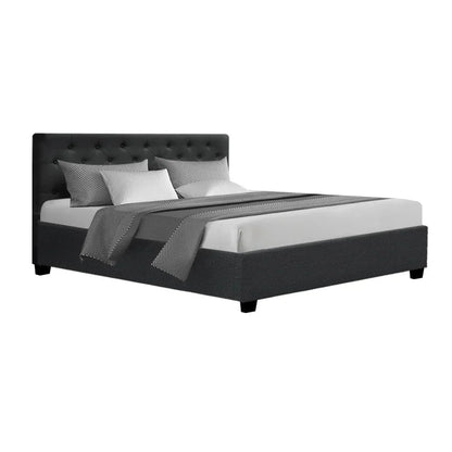 Modern charcoal upholstered bed frame with tufted headboard and bedding, isolated on white