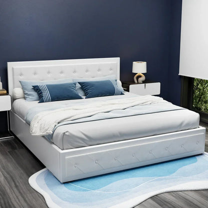White upholstered bed frame with tufted headboard, blue accent pillows, and modern bedroom decor.