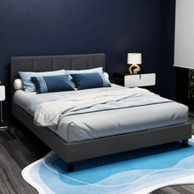 Modern upholstered bed with grey headboard, blue bedding, and nightstands in a stylish bedroom