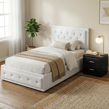White tufted bed frame with storage, cozy bedding, and modern bedside table in bright bedroom