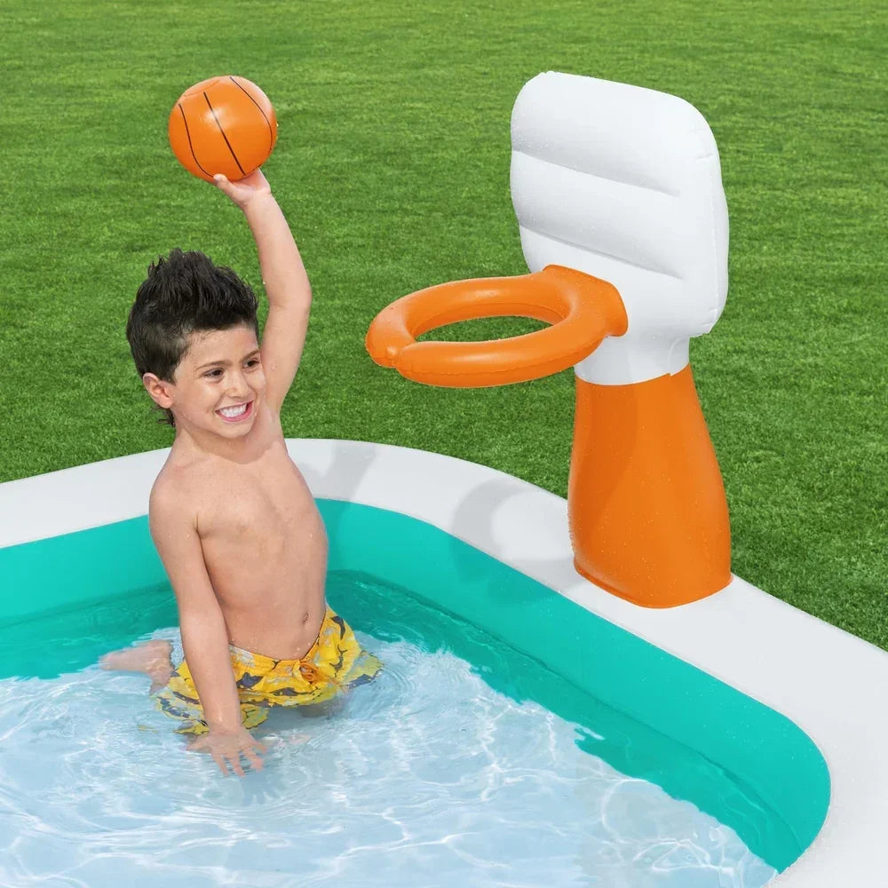 Child playing basketball in inflatable pool with floating hoop on green lawn