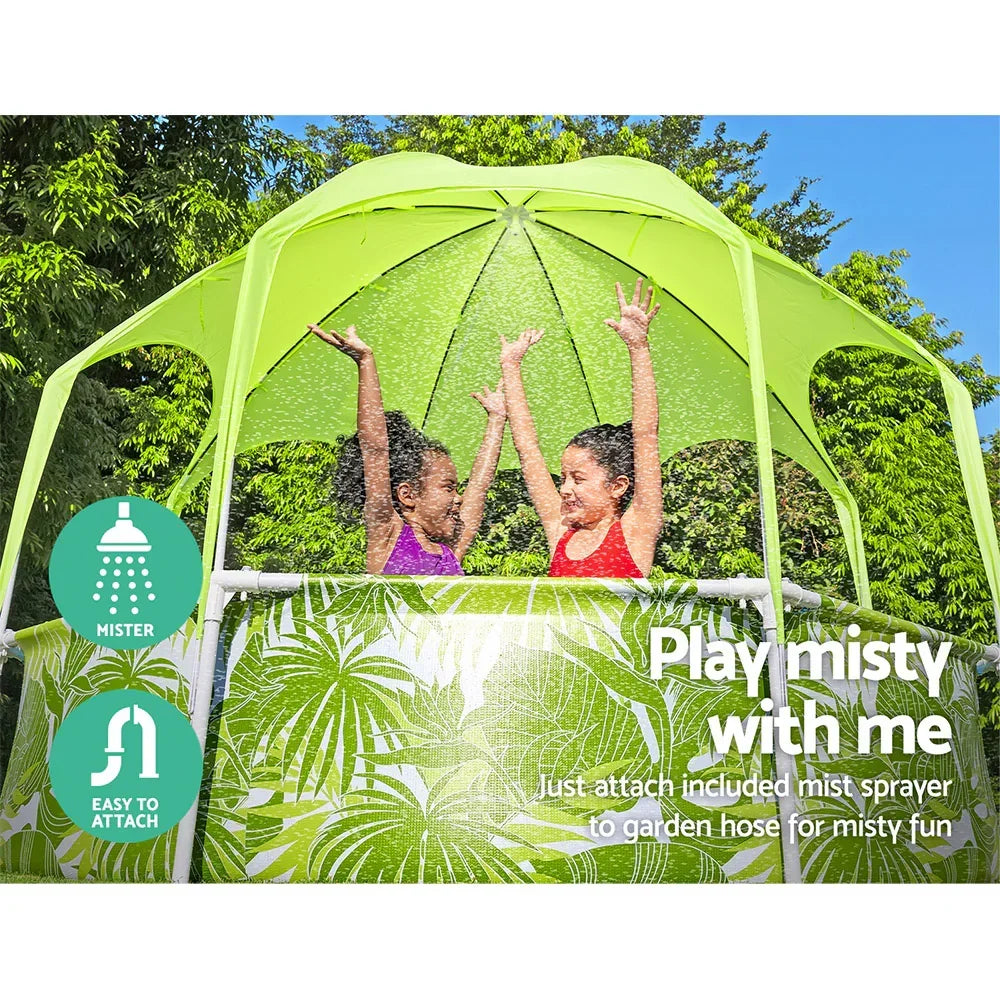 Two children playing in an outdoor pool with a green canopy and water mister, summer fun