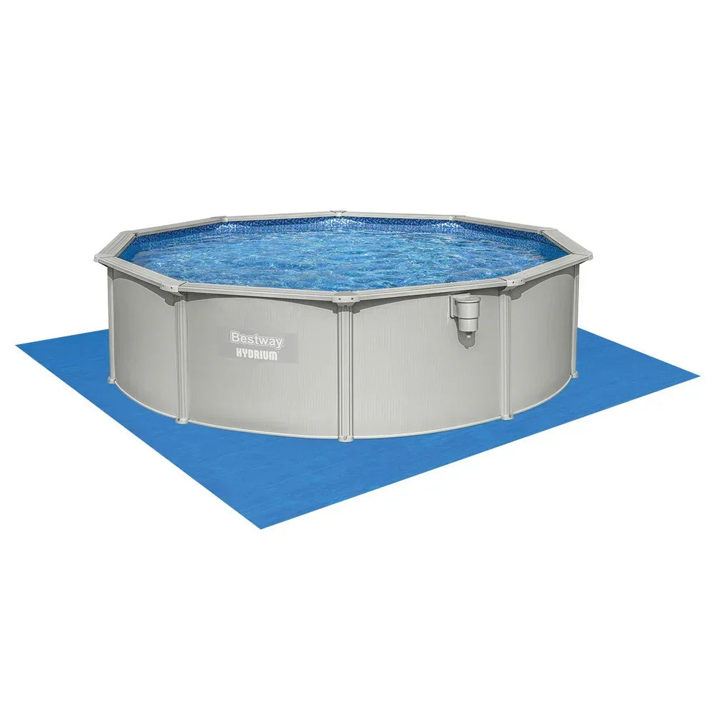 Round above ground metal pool with blue water on a blue mat, outdoor swimming pool