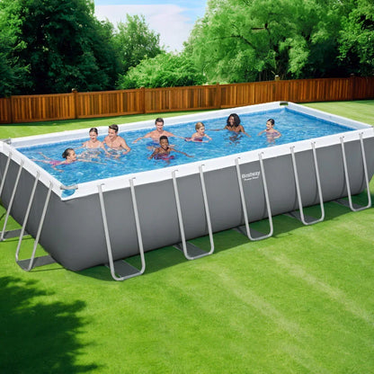 Large rectangular above ground pool with people swimming in a backyard setting