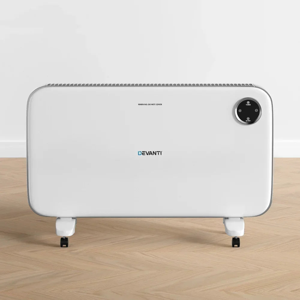 White electric panel heater with control panel and wheels on wooden floor indoors