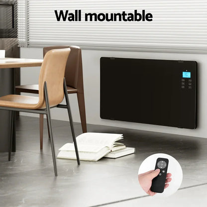 Wall mounted black glass panel heater with digital display and remote control in modern room.