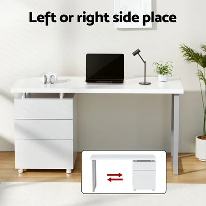 Modern white office desk with drawers, laptop, lamp, and plants, reversible drawer setup