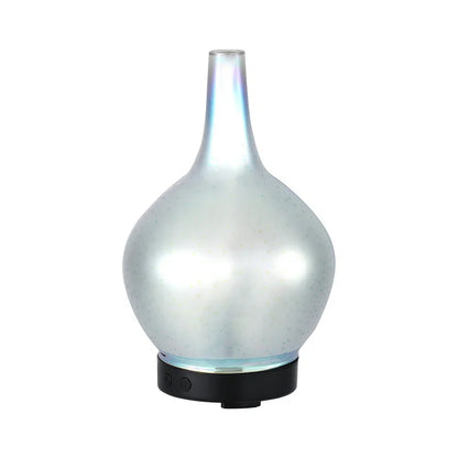 Modern glass essential oil diffuser with iridescent finish and black base on white background