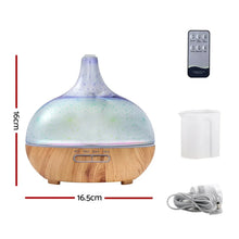Aromatherapy essential oil diffuser with wood grain base, remote control, measuring cup, and power cord, 16x16.5cm.