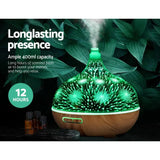 Colorful LED essential oil diffuser with 400ml capacity emitting mist, surrounded by greenery.