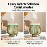 A modern wood-grain essential oil diffuser with two mist modes on a living room table.