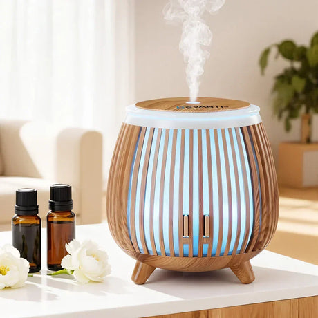 Modern wooden essential oil diffuser with LED light, steam, and oils on a table in a living room