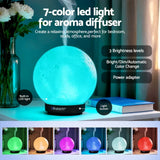7-color LED moon lamp aroma diffuser with steam, adjustable brightness, and color options on a desk.