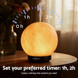 Moon-shaped aroma diffuser with calming mist and timer, sitting on a wooden table.