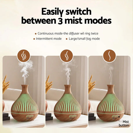 Wood grain essential oil diffuser with three mist modes, emitting vapor on a tabletop indoors.