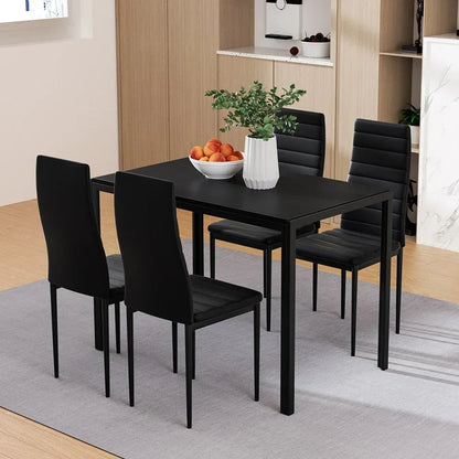 Modern black dining table set with four chairs, centerpiece vase and fruit bowl in kitchen