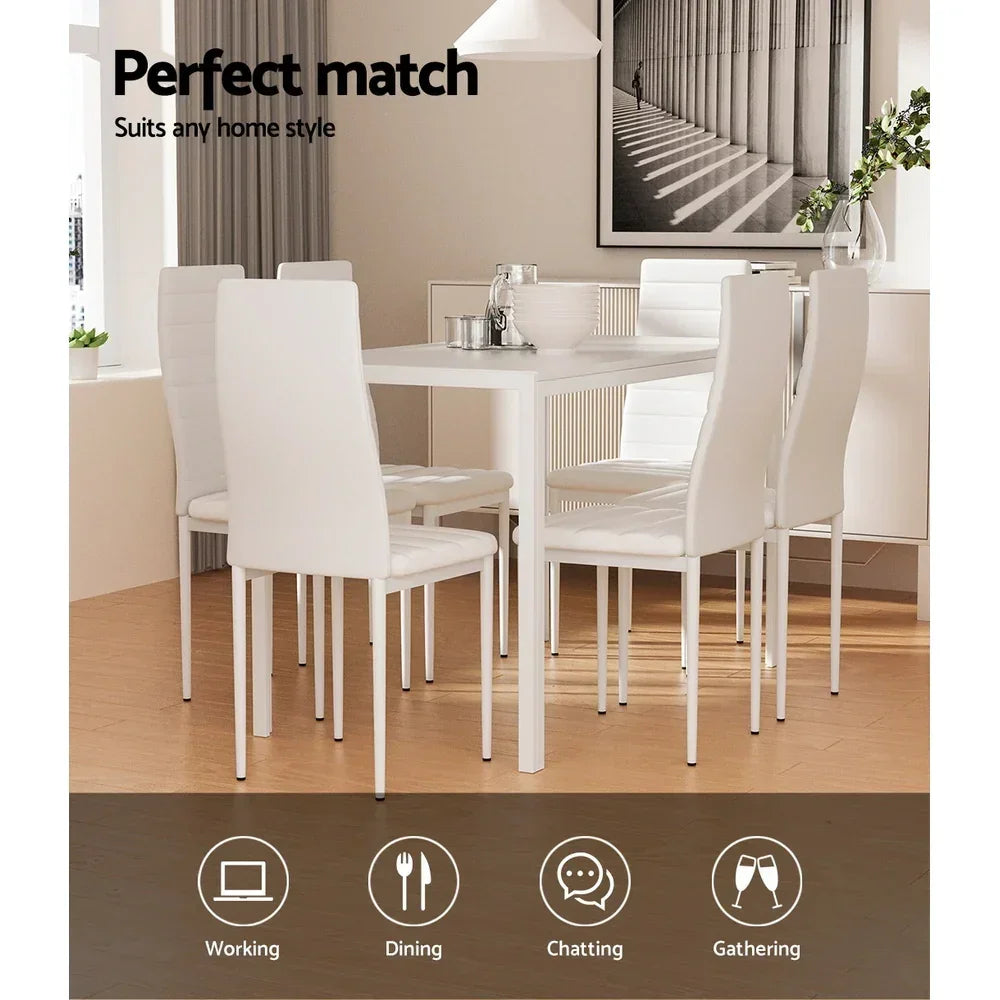 Modern white dining table set with six chairs in a bright, contemporary dining room