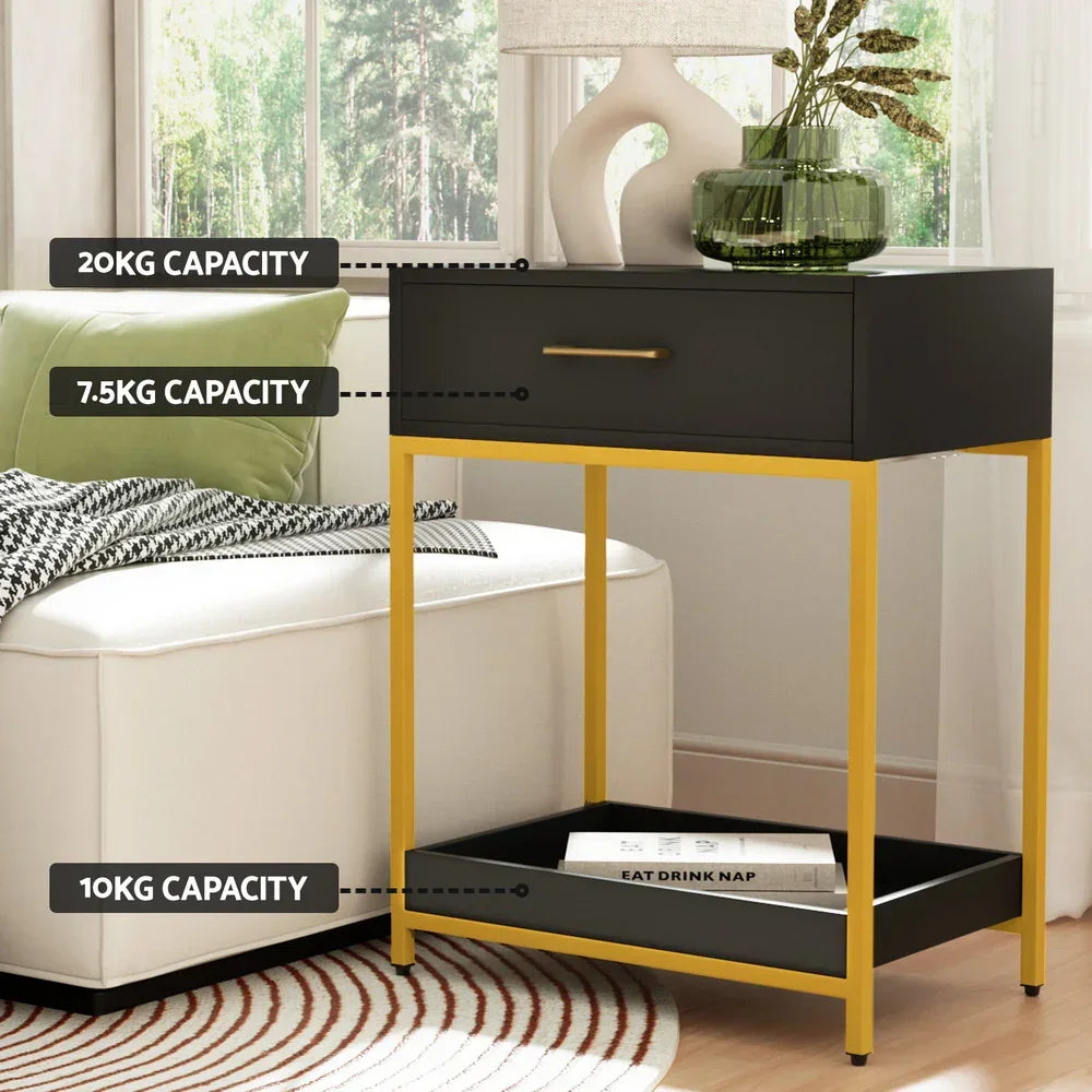 Black and gold side table with drawer and shelf, labeled weight capacities, beside a sofa.