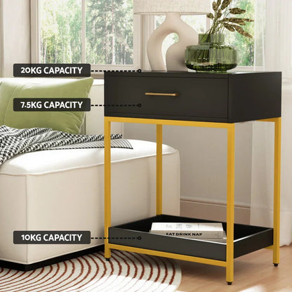 Black and gold side table with drawer and shelf, labeled weight capacities, beside a sofa.