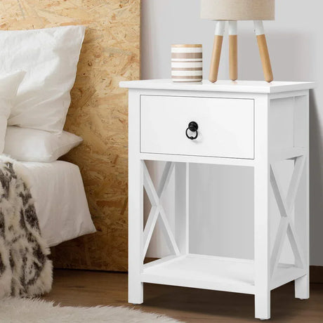 White wooden bedside table with drawer, lower shelf, and modern decor in a bedroom setting