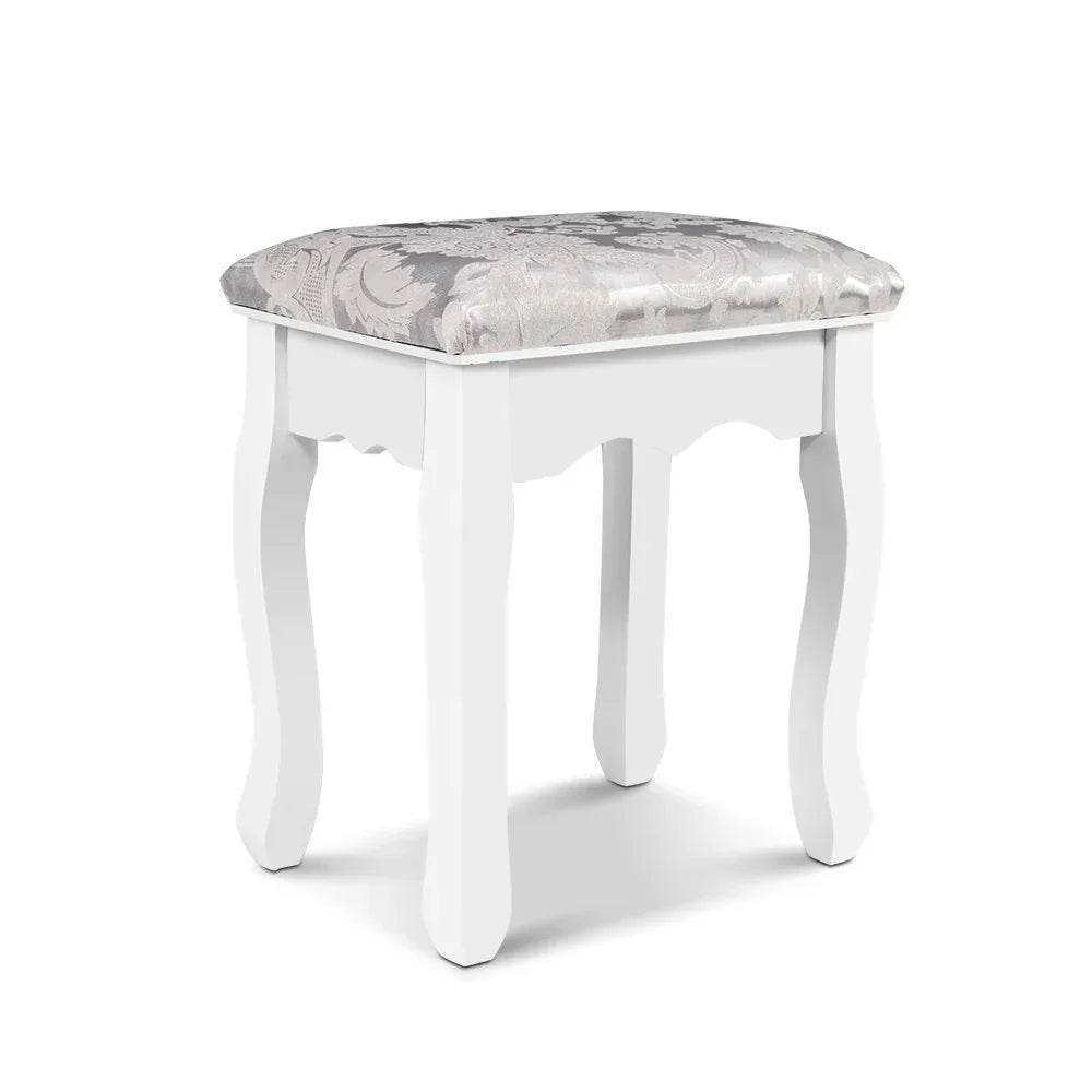 White wooden vanity stool with patterned cushioned seat and curved legs on white background