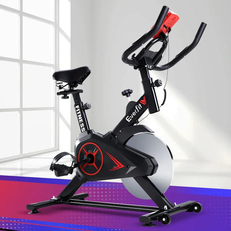 Black indoor exercise bike with red accents, adjustable seat and handlebars, modern home gym