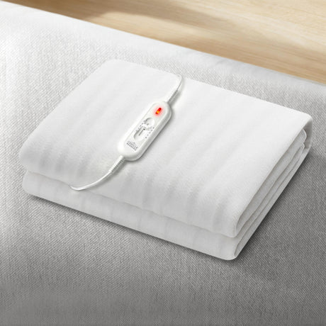 White electric blanket with attached control switch on a bed, bedding accessory