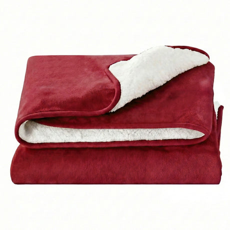 Plush red throw blanket with white sherpa lining, folded on a white background
