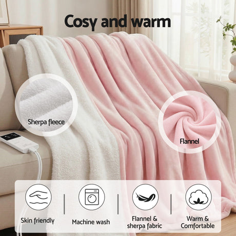 Pink and white flannel sherpa electric throw blanket draped over a sofa in a cozy living room.