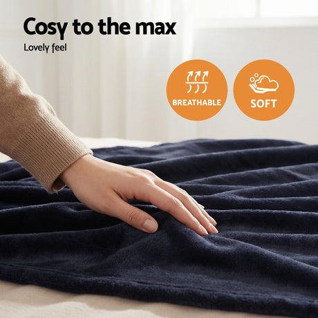 Hand touching soft, breathable navy blue throw rug on bed with cosy, comfortable feel.