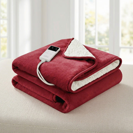 Folded red electric throw blanket with white sherpa lining and digital controller on beige surface