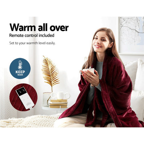 Woman relaxing with a burgundy heated throw blanket, remote control, in cozy living room.