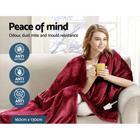 Woman relaxing on a couch with a red throw rug, antibacterial and dust mite resistant, 160x130cm.