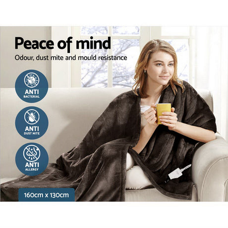Woman on sofa with brown throw rug, holding yellow mug, anti-allergy, anti-bacterial features