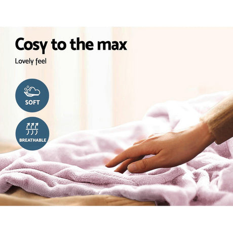 Hand touching soft, breathable pink throw rug on bed in bright room