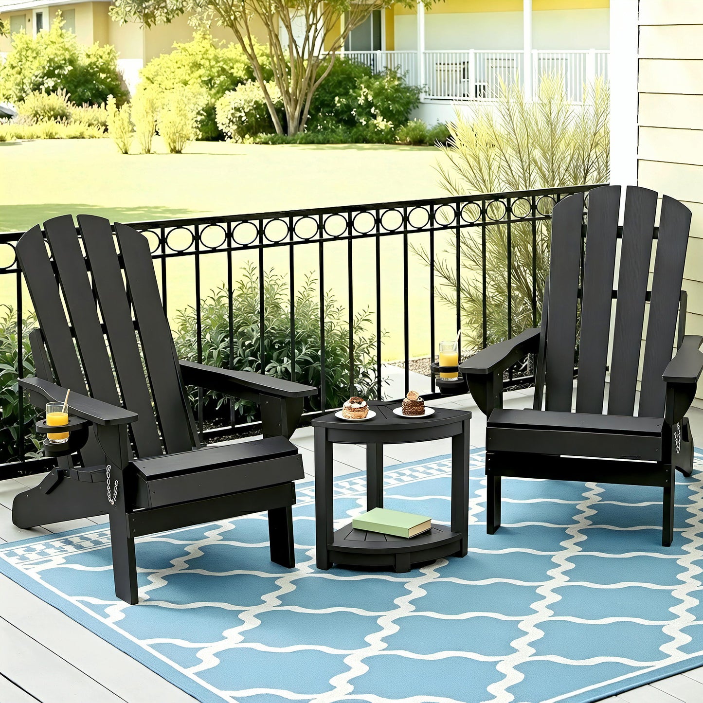 Black Adirondack patio chairs with side table on blue patterned rug, perfect for outdoor relaxation.
