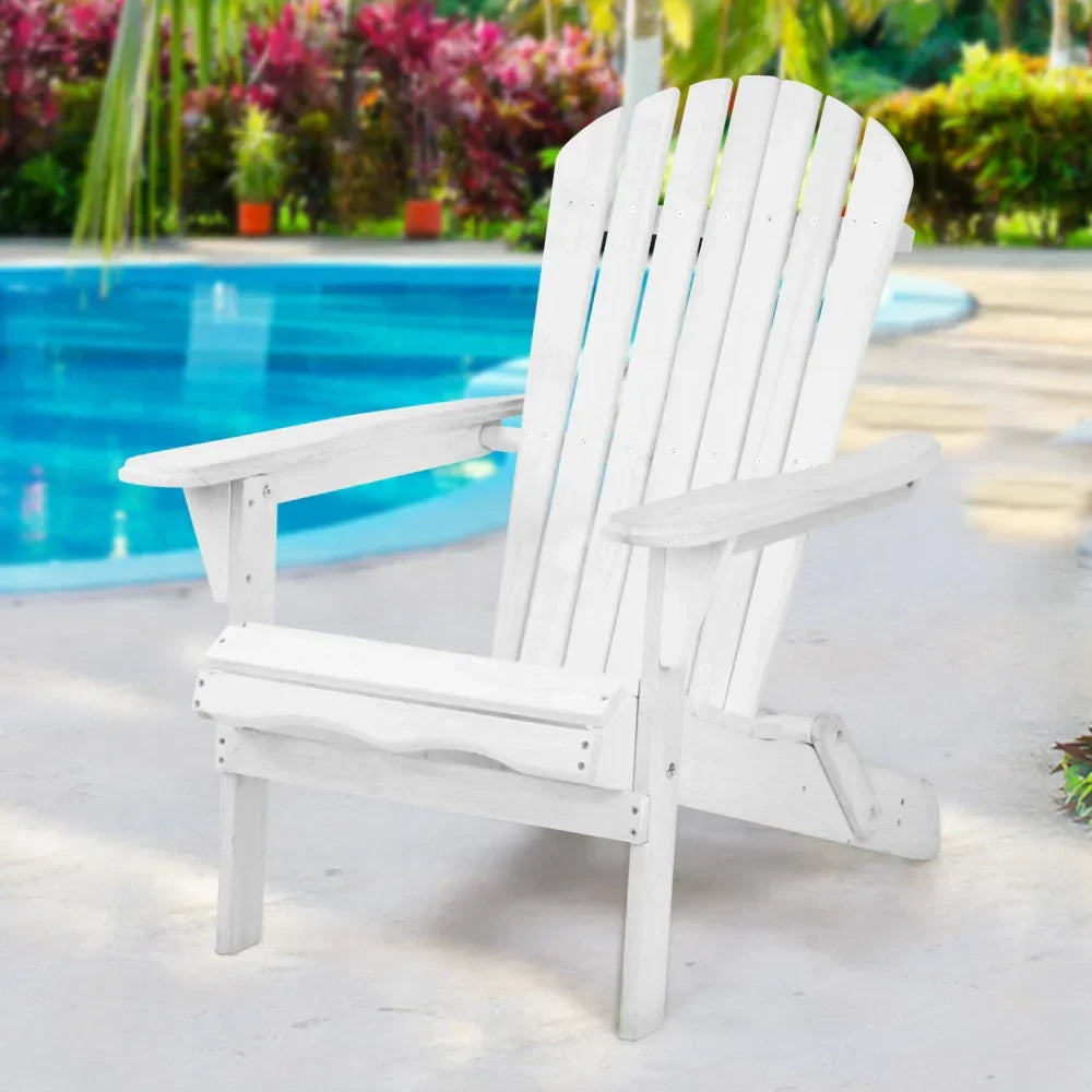White Adirondack chair by a swimming pool with tropical plants in the background