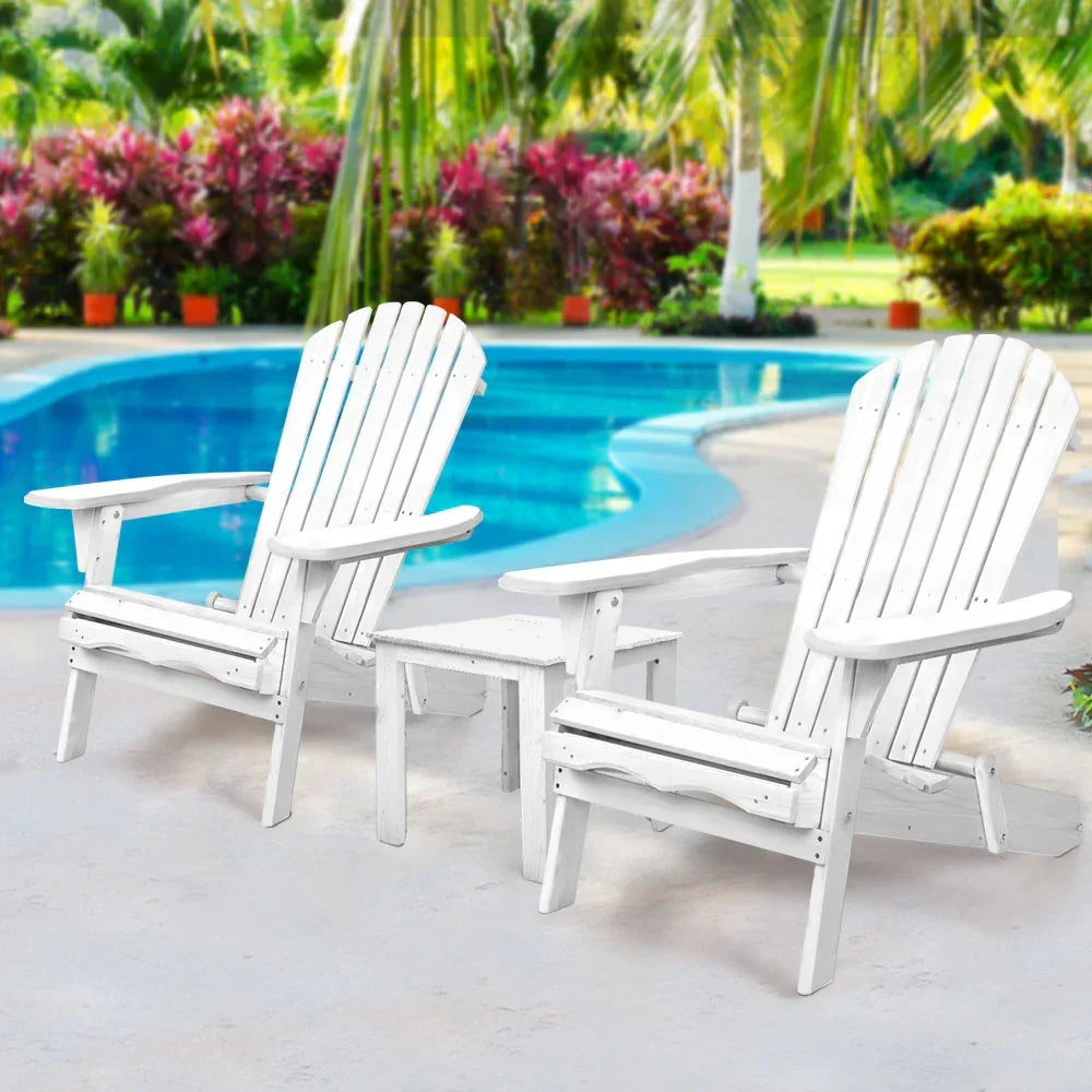 White Adirondack chairs and side table by poolside in tropical outdoor setting