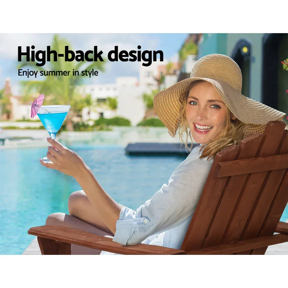 Woman relaxing on wooden high-back outdoor chair by pool, wearing sun hat, holding blue cocktail.