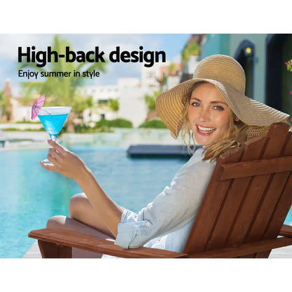Woman relaxing on wooden high-back outdoor chair by pool, wearing sun hat, holding blue cocktail.