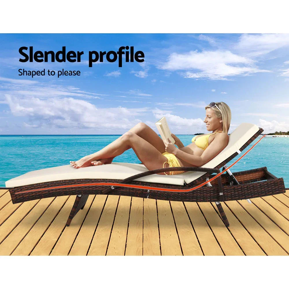Outdoor rattan lounge chair with cushion on deck by the ocean, woman reading in swimsuit