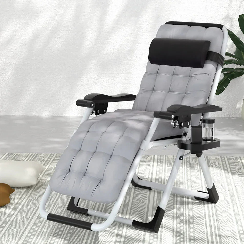 Padded grey reclining lounge chair with headrest, cup holder, and armrests on a patterned rug