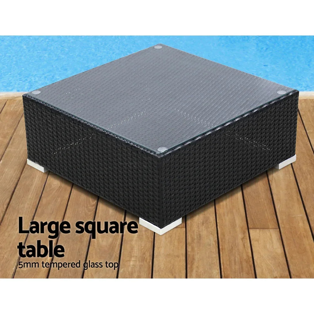 Large outdoor square rattan coffee table with tempered glass top on wooden deck near pool