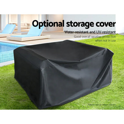 Black outdoor furniture cover on grass near pool, water-resistant UV-protective storage for sofas