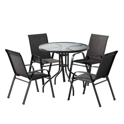 Outdoor dining set with round glass table and four black metal chairs