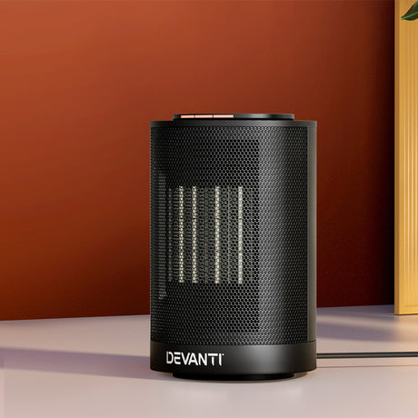 Black Devanti electric ceramic tower heater on table against red wall