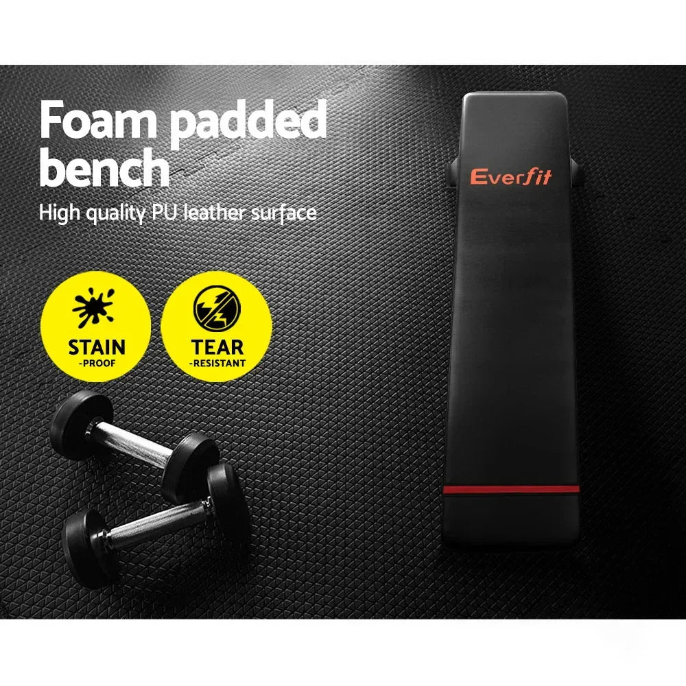 Foam padded flat workout bench with PU leather surface, two dumbbells, textured gym floor