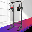 Power tower chin-up and dip station in a modern indoor setting, black and red accents